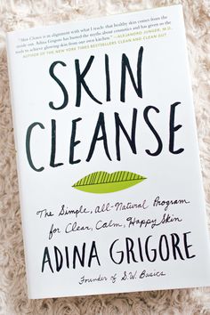 the book skin cleanse by adna grigore is laying on a blanket