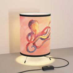 an octopus lamp on a table next to a charger with a plug in it