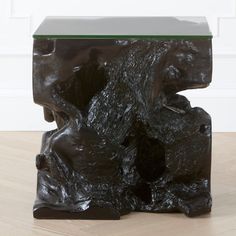 a black sculpture sitting on top of a wooden floor