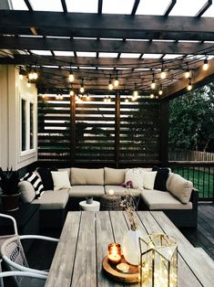 an outdoor living area with couches, tables and lights on the roof top deck