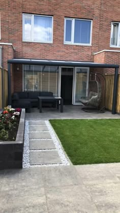 an outdoor patio area with green grass and wooden fenced in areas around it, including a black couch