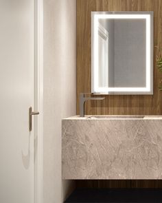 a bathroom sink sitting under a large mirror next to a wooden wall mounted faucet