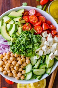 a bowl filled with cucumber, tomatoes, chickpeas and lettuce