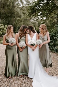 the bridesmaids are all dressed in different styles and colors, including olive green dresses