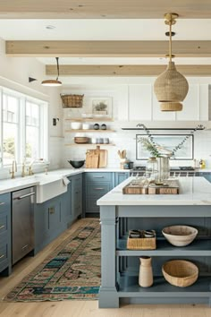 a large kitchen with blue cabinets and white counter tops, an island in the middle