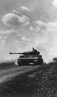 two tanks driving down a dirt road