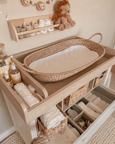 a baby's changing table with lots of diapers and toys in it,