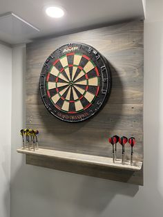 a dart board mounted to the side of a wall with darts in front of it