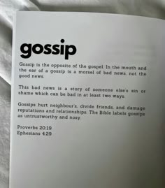 a close up of a book on a bed with white sheets and black text that reads gossip