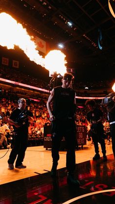 a man standing on top of a basketball court holding a fire extinguisher