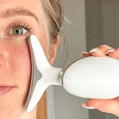 a woman holding a hair dryer in front of her face