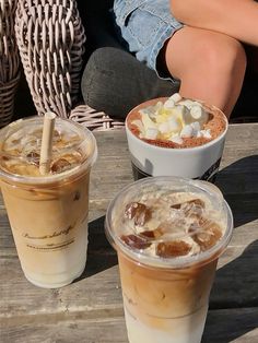 three drinks are sitting on a wooden table