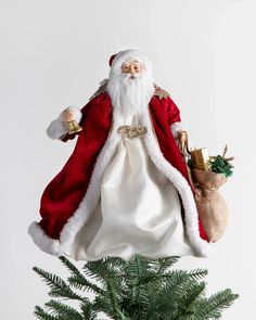 a santa clause figurine sitting on top of a christmas tree