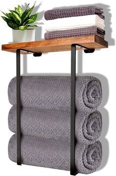 a shelf with towels and a potted plant on it