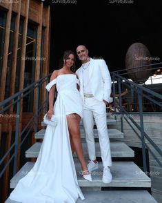 a man and woman in white outfits standing on stairs