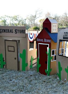 several cardboard buildings with cactus decorations on them and the words general store painted on them