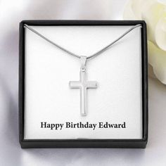 a necklace with a cross on it in a box next to a white rose and the words happy birthday thomas