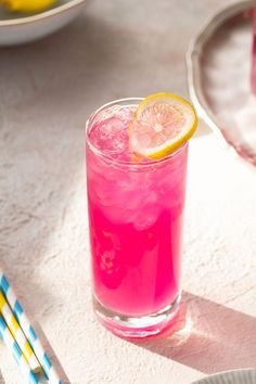 a pink drink with lemon slices on the rim