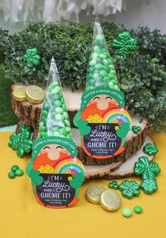 some green candies sitting on top of a tree stump next to cookies and candy