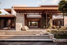 a modern house with stone steps leading up to the front door and covered patio area