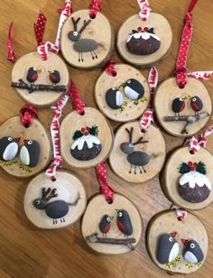 wooden ornaments with birds on them are hanging from red and white ribboned ribbons,