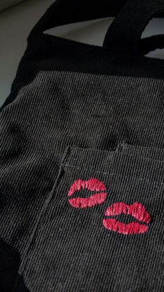 a black bag with red lipstick painted on the front and side of it's pocket