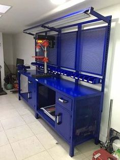 a blue workbench in a garage with tools on the counter and shelves below