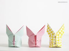 three origami rabbits are lined up in different colors