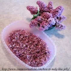 purple flowers sitting in a plastic container on a table