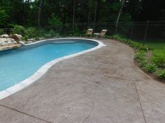 an empty swimming pool surrounded by lush green trees