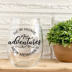 a wine glass sitting on top of a wooden table next to a potted plant