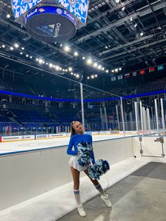 a cheerleader standing in front of an ice rink