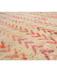 an area rug with various colors and patterns on it, including pinks, oranges, and reds