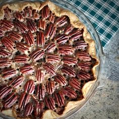 a pie with pecans in it sitting on top of a table