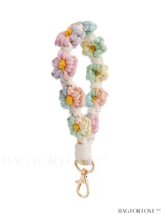 a white and pink flower bracelet with gold clasps on a white background is shown