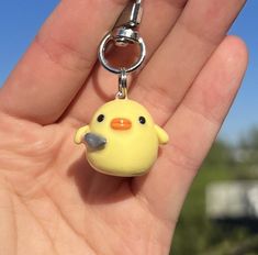 a yellow rubber ducky keychain hanging from a hand