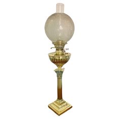 an old fashioned lamp with a glass ball on it's top and base, against a white background