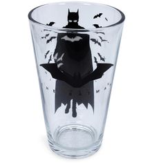 a glass cup with batman silhouettes on the side and bats flying around it,