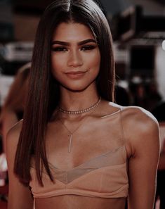 a close up of a person wearing a bra and choker on the red carpet