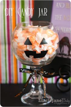 a glass bowl filled with candy and jack - o'- lantern candies on top of a table