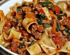 a white bowl filled with pasta and meat