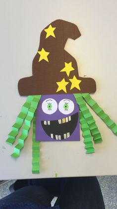 a paper cut out of a purple hat with stars on it and a smiling face