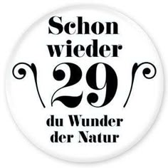 a badge with the number 29 in black and white, which reads schon wieder