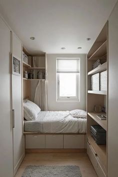 a small bedroom with a bed and shelves in the corner, along with a rug on the floor