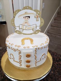 a white and gold decorated cake on top of a table