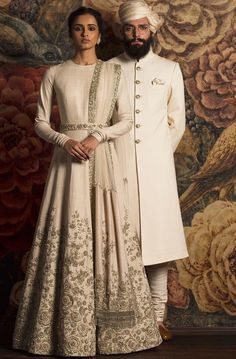 Ivory Color Wedding Gown – Panache Haute Couture Formal Anarkali Gown In Raw Silk, Formal Anarkali Raw Silk Gown, Elegant Raw Silk Sherwani For Reception, Formal Raw Silk Gown With Zari Work, Beige Anarkali Dress For Wedding, Beige Anarkali Wedding Gown, Elegant Floor-length Sherwani With Intricate Embroidery, Silk Sherwani With Zari Work For Wedding, Traditional Beige Wedding Dress