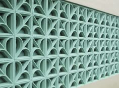 a close up view of a decorative wall made out of green metal bars and circles