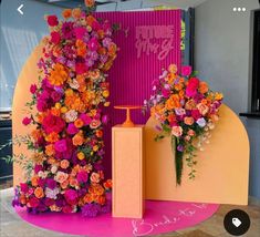 two tall vases filled with colorful flowers sitting on top of a pink and yellow floor