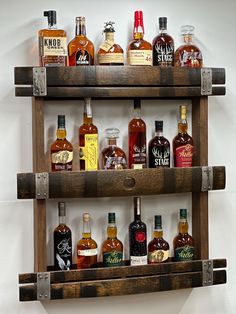 a wooden shelf filled with lots of different types of liquors on top of each other