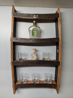 a wooden shelf with glasses on it and a bottle in the corner next to it